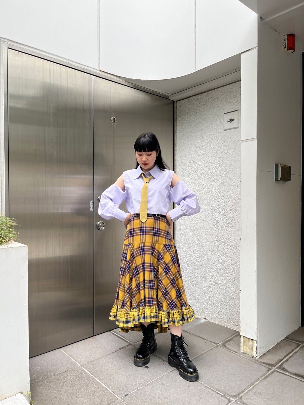 イエロー系のスカート、ブルー系のシャツ/ブラウス、ブラック系のその他シューズを着用したレディースの春コーディネートの2枚目の写真