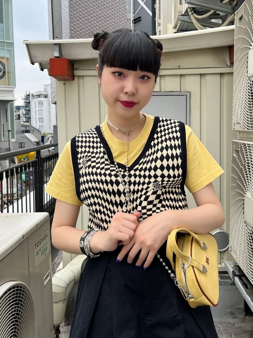 ブラック系のブーツ、ブラック系のニット/セーター、イエロー系のTシャツ/カットソーを着用したレディースの夏コーディネートの3枚目の写真