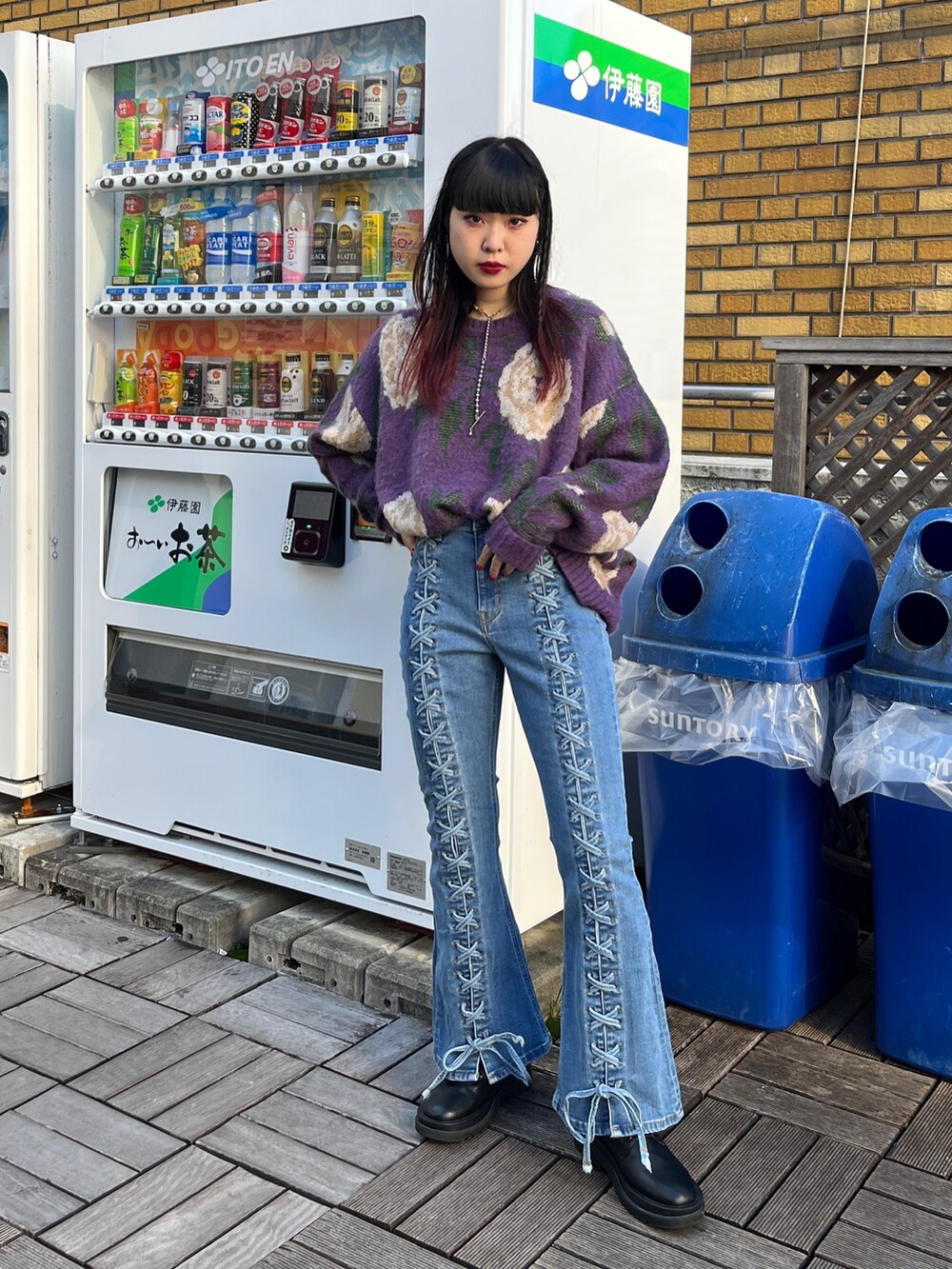 ブルー系のデニムパンツ、ブラック系のニット/セーター、ブラック系のブーツを着用したレディースの秋コーディネートの2枚目の写真