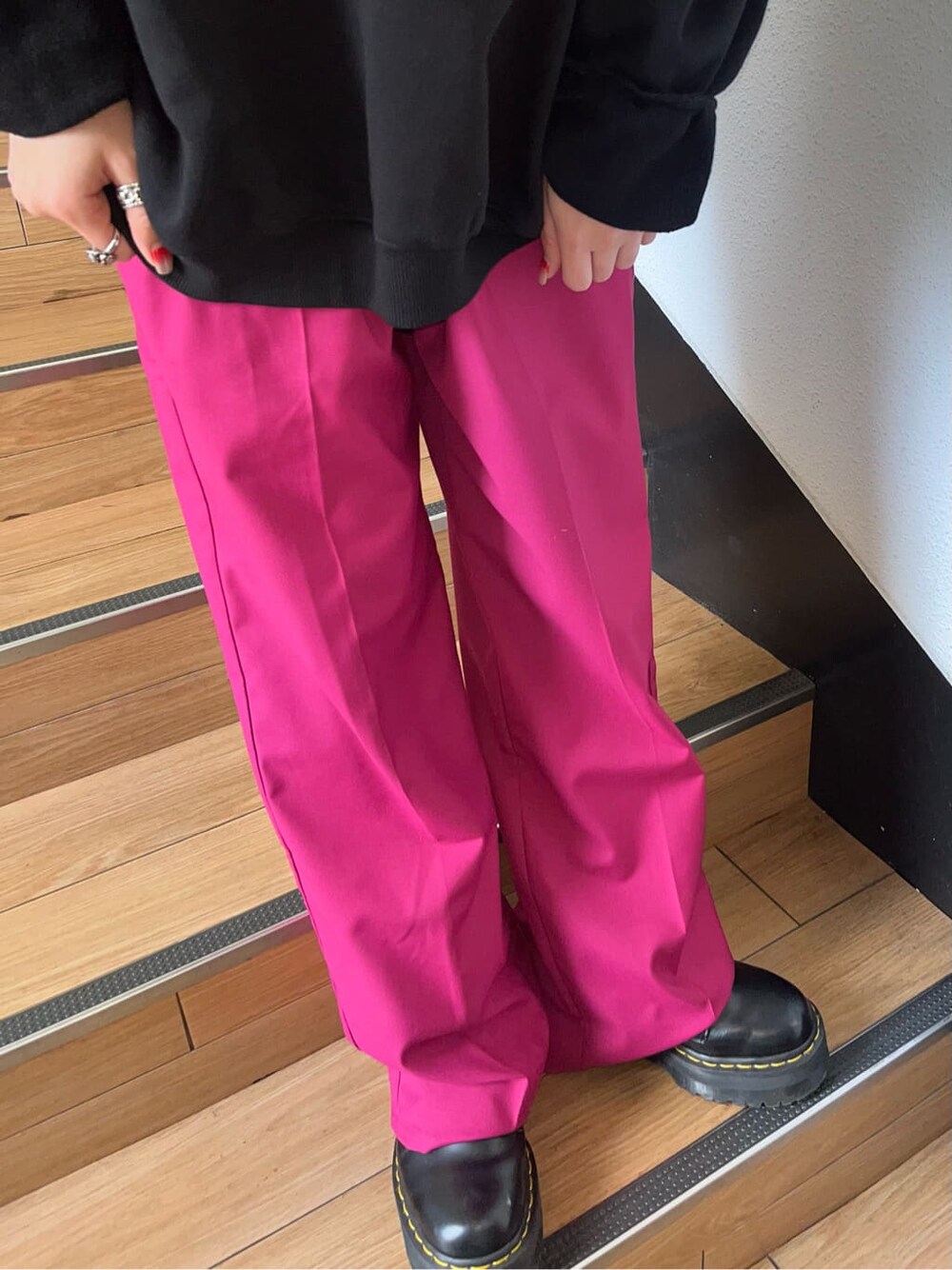 ピンク系のスラックス、ブラック系のスウェットを着用したレディースの冬コーディネートの4枚目の写真