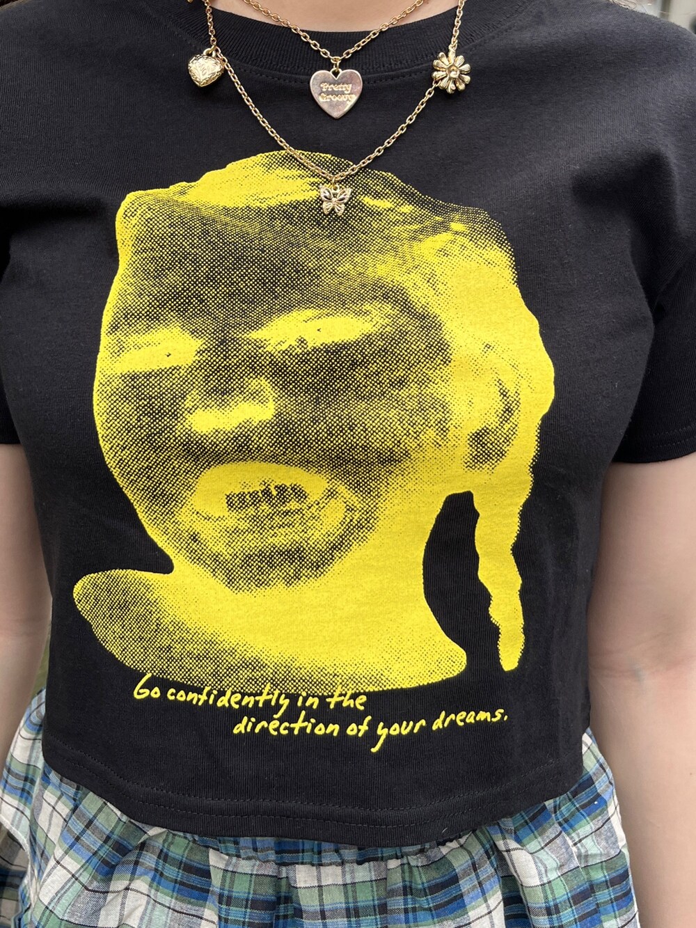 グリーン系のスカート、ブラック系のTシャツ/カットソー、ブラック系のブーツを着用したレディースの夏コーディネートの6枚目の写真