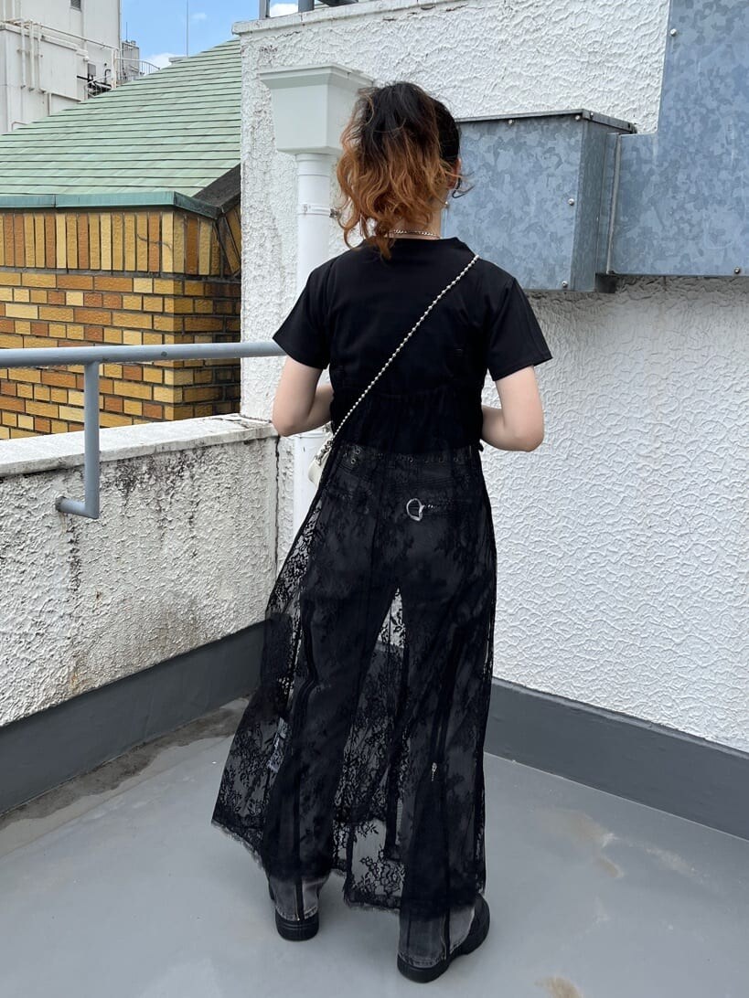 ブラック系のワンピース、ブラック系のデニムパンツ、ホワイト系のボストンバッグを着用したレディースの夏コーディネートの3枚目の写真