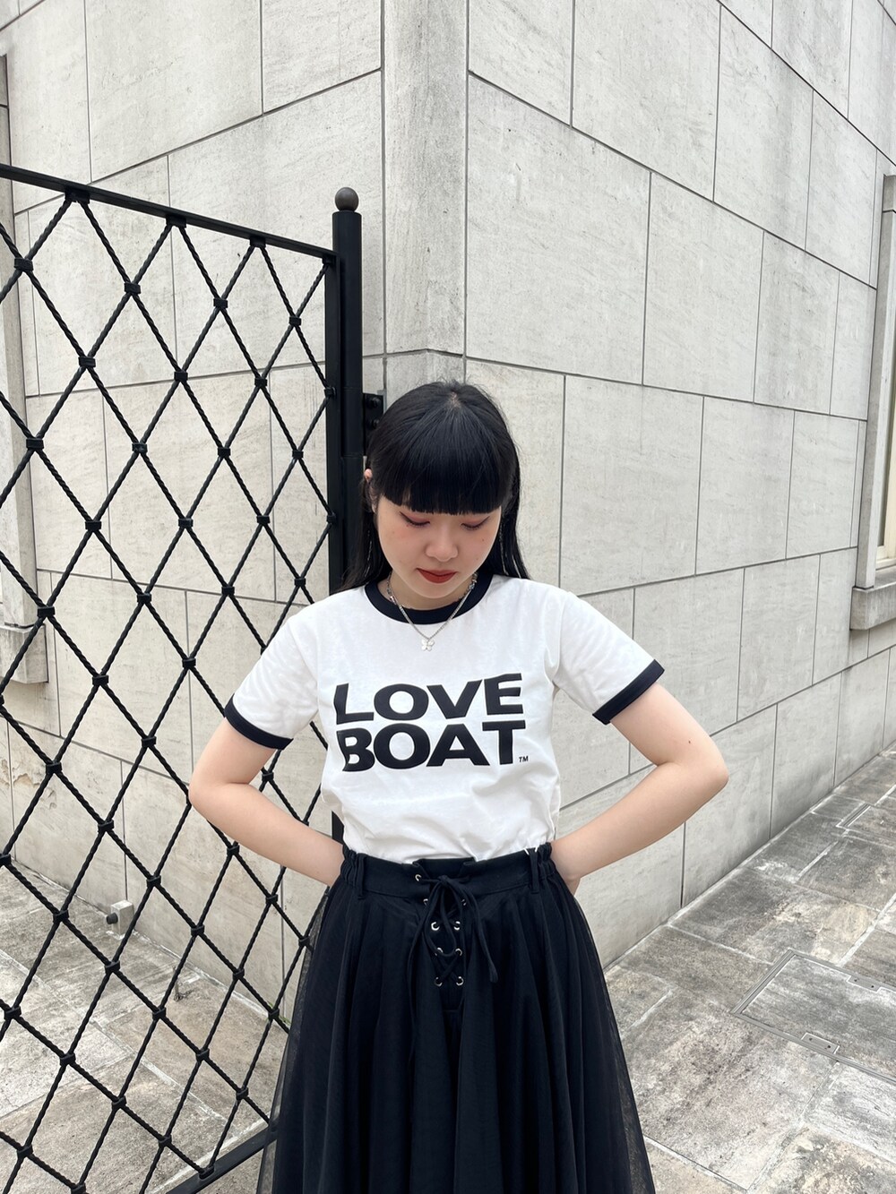 ホワイト系のTシャツ/カットソー、ブラック系のスカート、シルバー系のネックレスを着用したレディースの夏コーディネートの3枚目の写真
