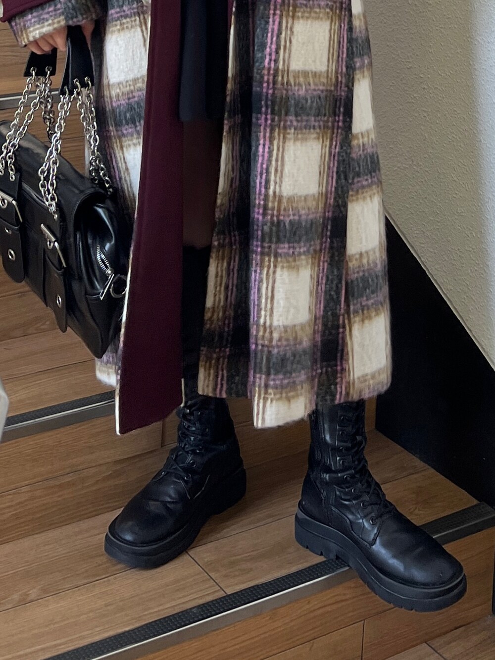 ブラック系のブーツ、ブラック系のハンドバッグ、ホワイト系のチェスターコートを着用したレディースの夏コーディネートの5枚目の写真