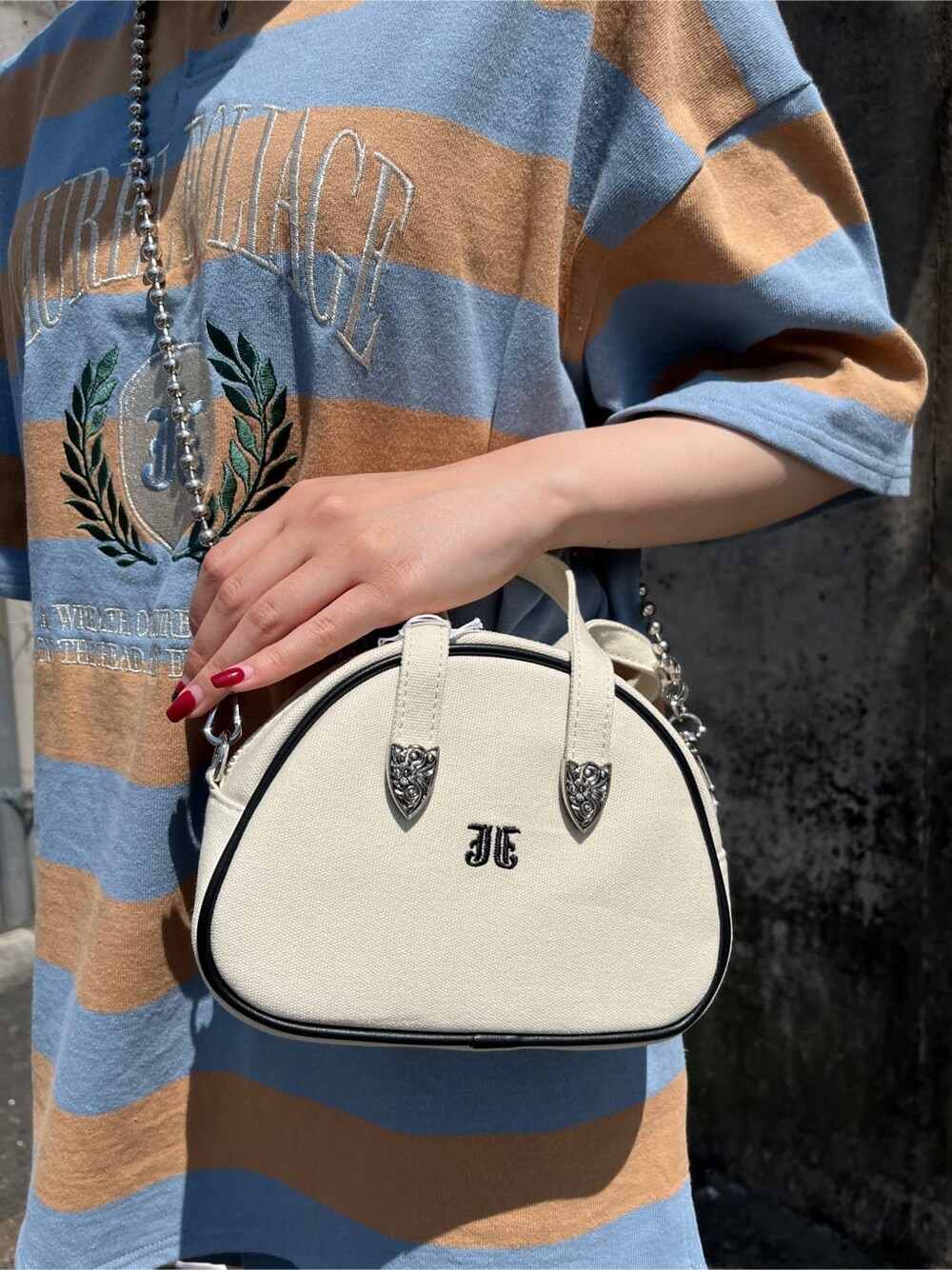 ブラック系のブーツ、ブルー系のその他パンツ、ホワイト系のボストンバッグを着用したレディースの春コーディネートの7枚目の写真