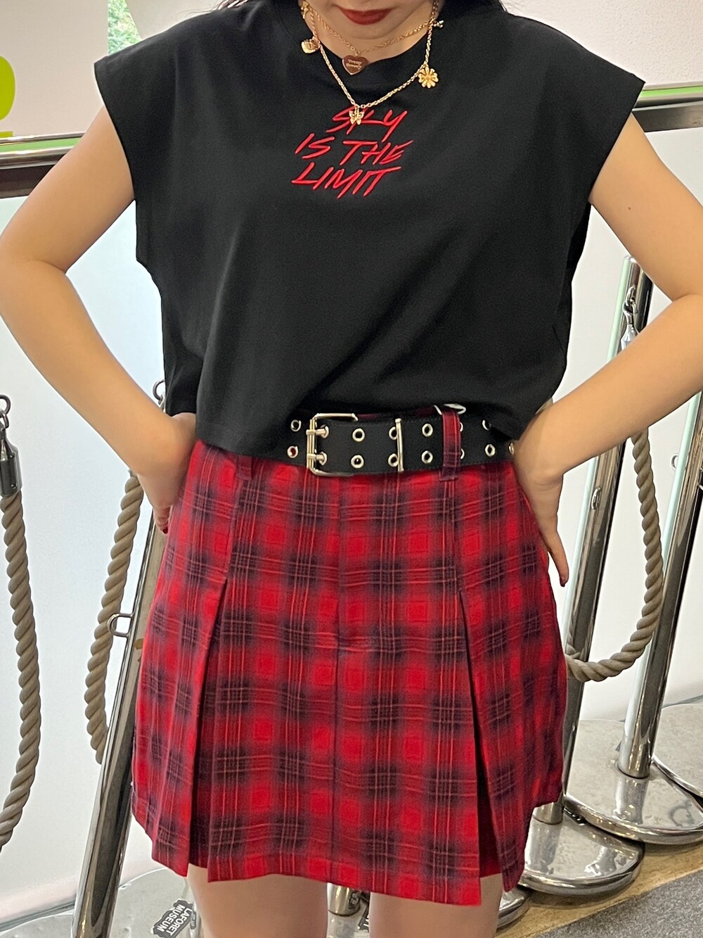 ブラック系のタンクトップ、レッド系のその他パンツ、ブラック系のブーツを着用したレディースの夏コーディネートの5枚目の写真