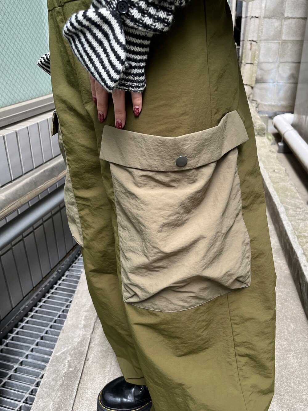 ホワイト系のTシャツ/カットソー、ブラック系のブーツ、ブラック系のアームカバーを着用したレディースの夏コーディネートの7枚目の写真