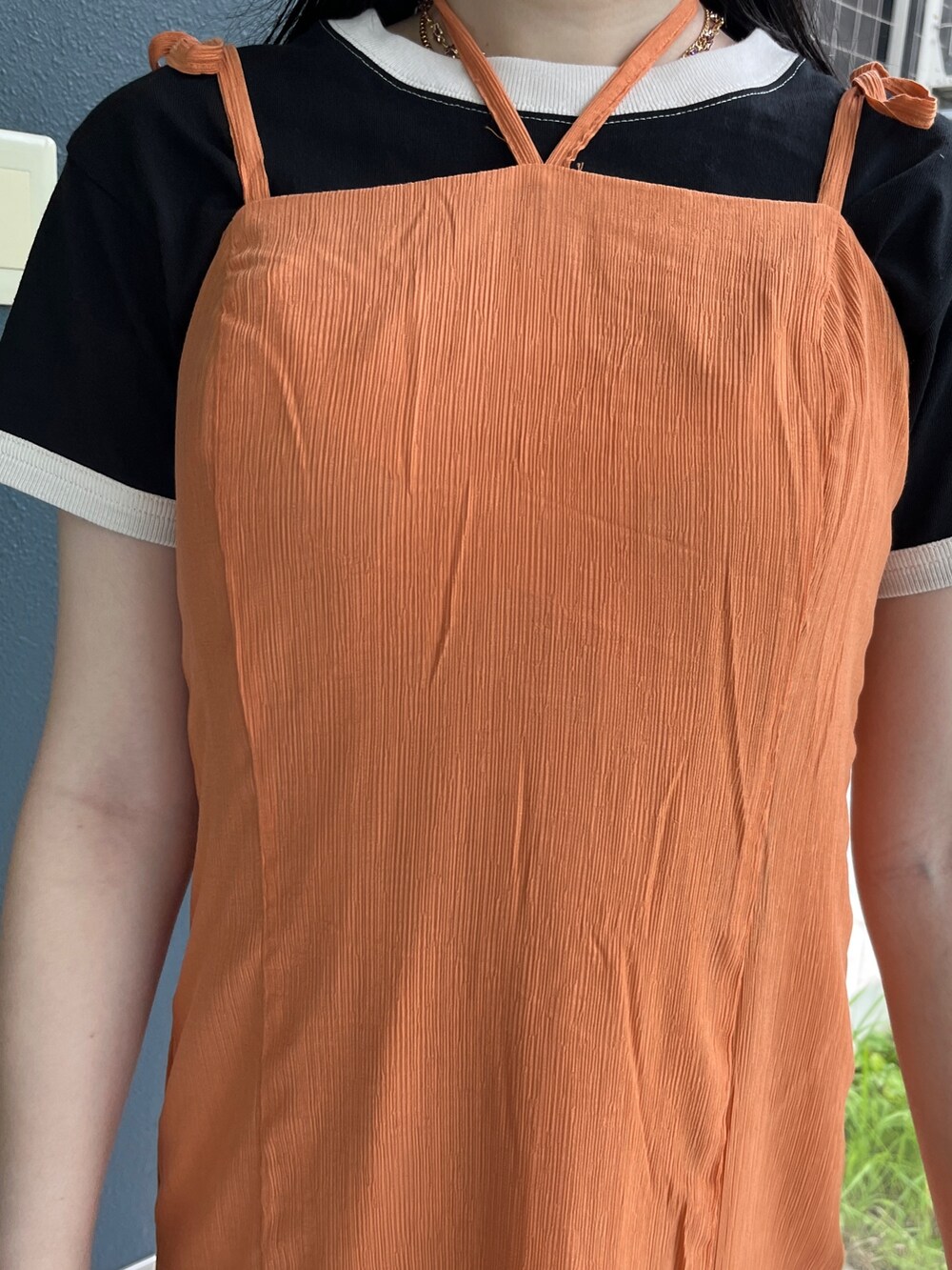 オレンジ系のワンピース、ホワイト系のTシャツ/カットソー、ブラック系のブーツを着用したレディースの夏コーディネートの6枚目の写真