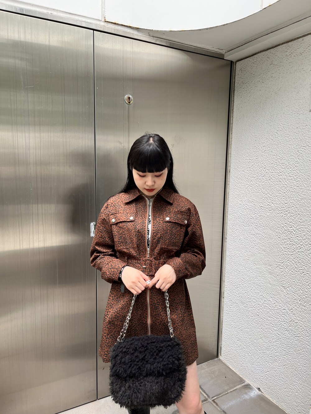 ブラック系のブーツ、ブラウン系のワンピース、ブラック系のハンドバッグを着用したレディースの夏コーディネートの4枚目の写真