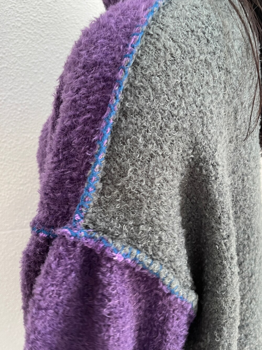 パープル系のニット/セーター、ブルー系のデニムパンツ、グリーン系のボストンバッグを着用したレディースの秋コーディネートの8枚目の写真