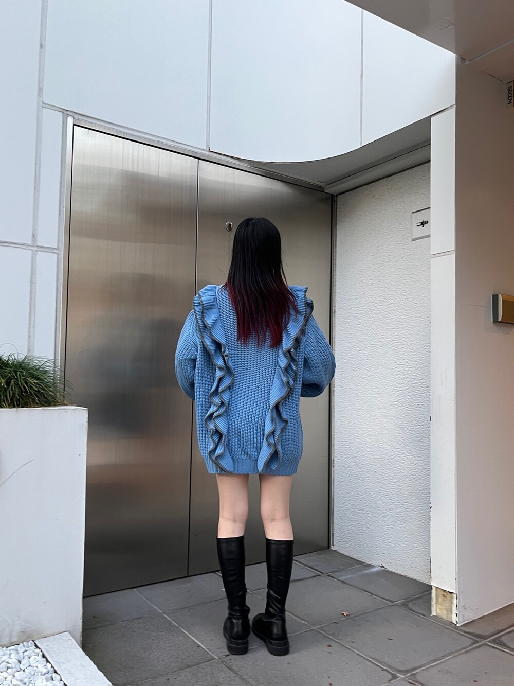 ブルー系のニット/セーター、ブラック系のブーツを着用したレディースの冬コーディネートの4枚目の写真