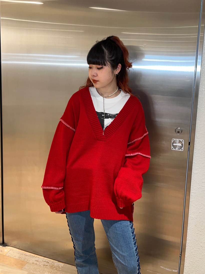 レッド系のニット/セーター、ホワイト系のTシャツ/カットソーを着用したレディースの冬コーディネートの2枚目の写真