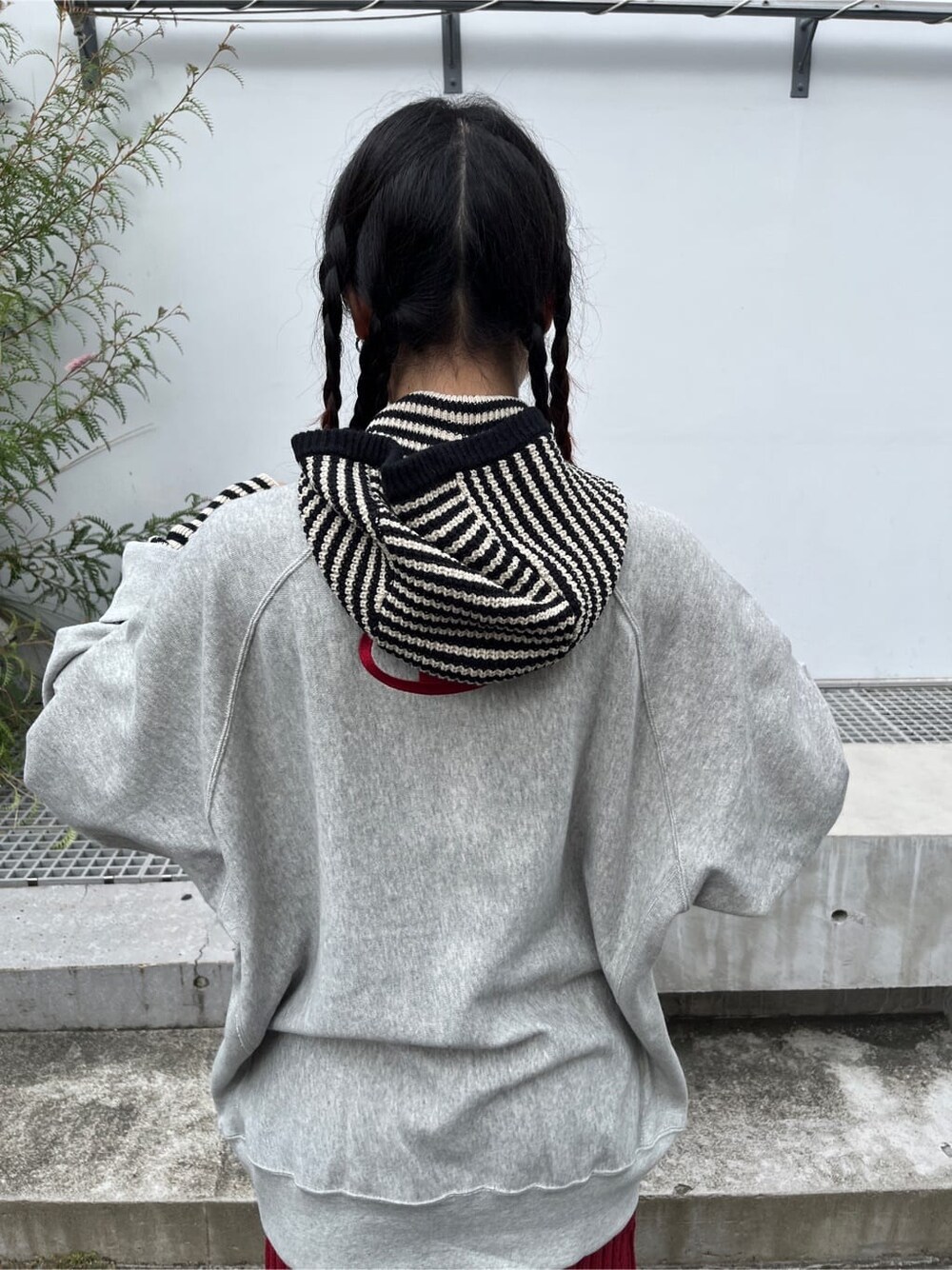 レッド系のスカート、グレー系のスウェット、ホワイト系のニットキャップ/ビーニーを着用したレディースの秋コーディネートの7枚目の写真