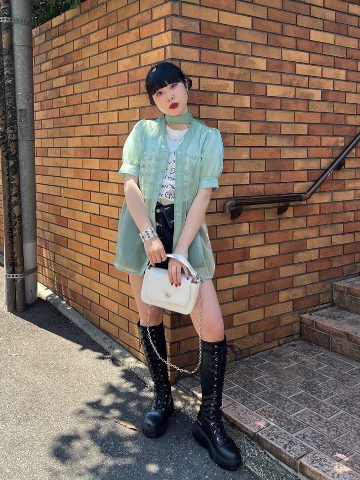 ブラック系のブーツ、ブラック系のデニムパンツ、グリーン系のシャツ/ブラウスを着用したレディースの春コーディネートの3枚目の写真