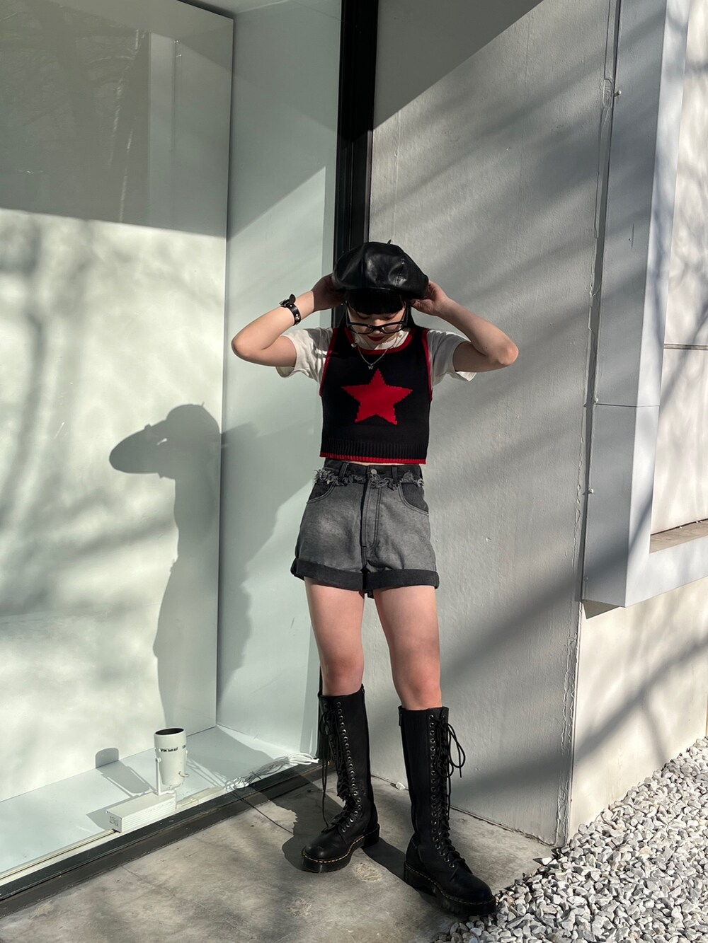 ブラック系のタンクトップ、ブルー系のデニムパンツ、ブラック系のハンチング/ベレー帽を着用したレディースの冬コーディネートの2枚目の写真