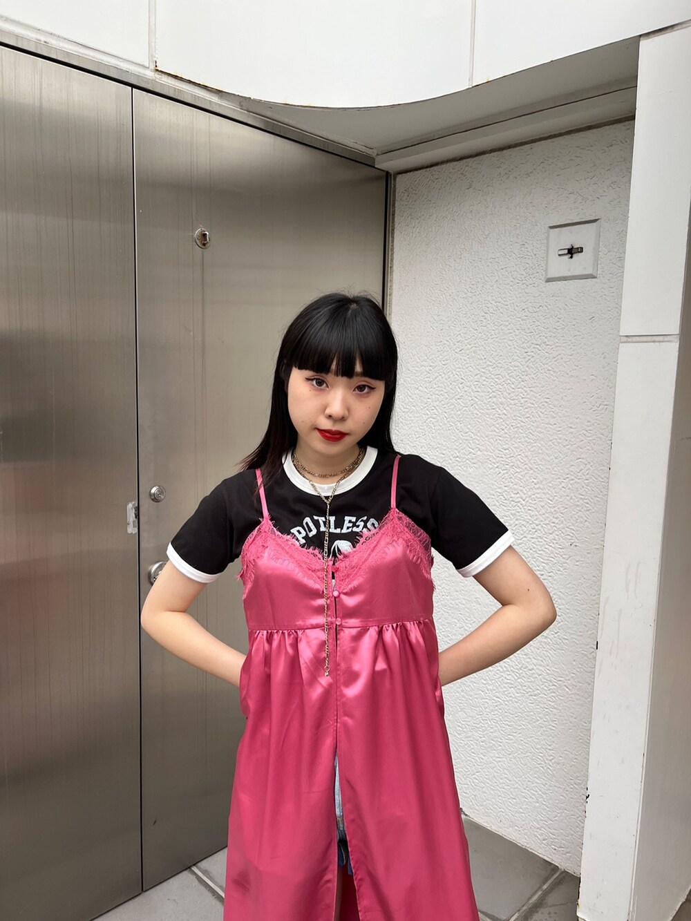 ピンク系のワンピース、ブラック系のブーツ、ブラック系のTシャツ/カットソーを着用したレディースの冬コーディネートの4枚目の写真