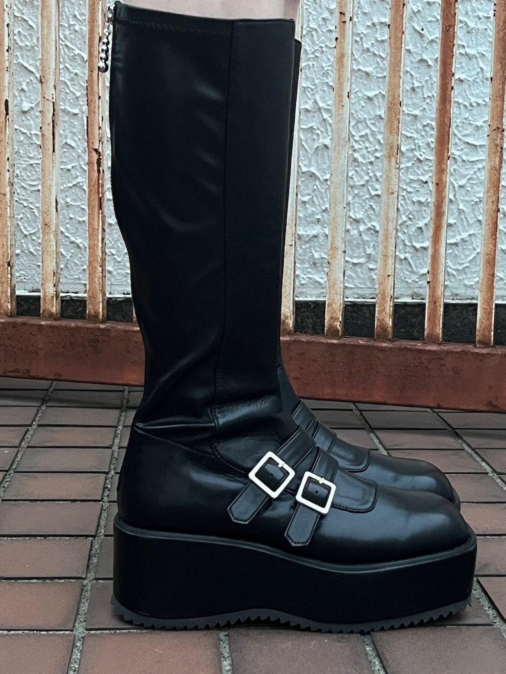 ブラック系のワンピース、ブラック系のブーツを着用したレディースの冬コーディネートの10枚目の写真