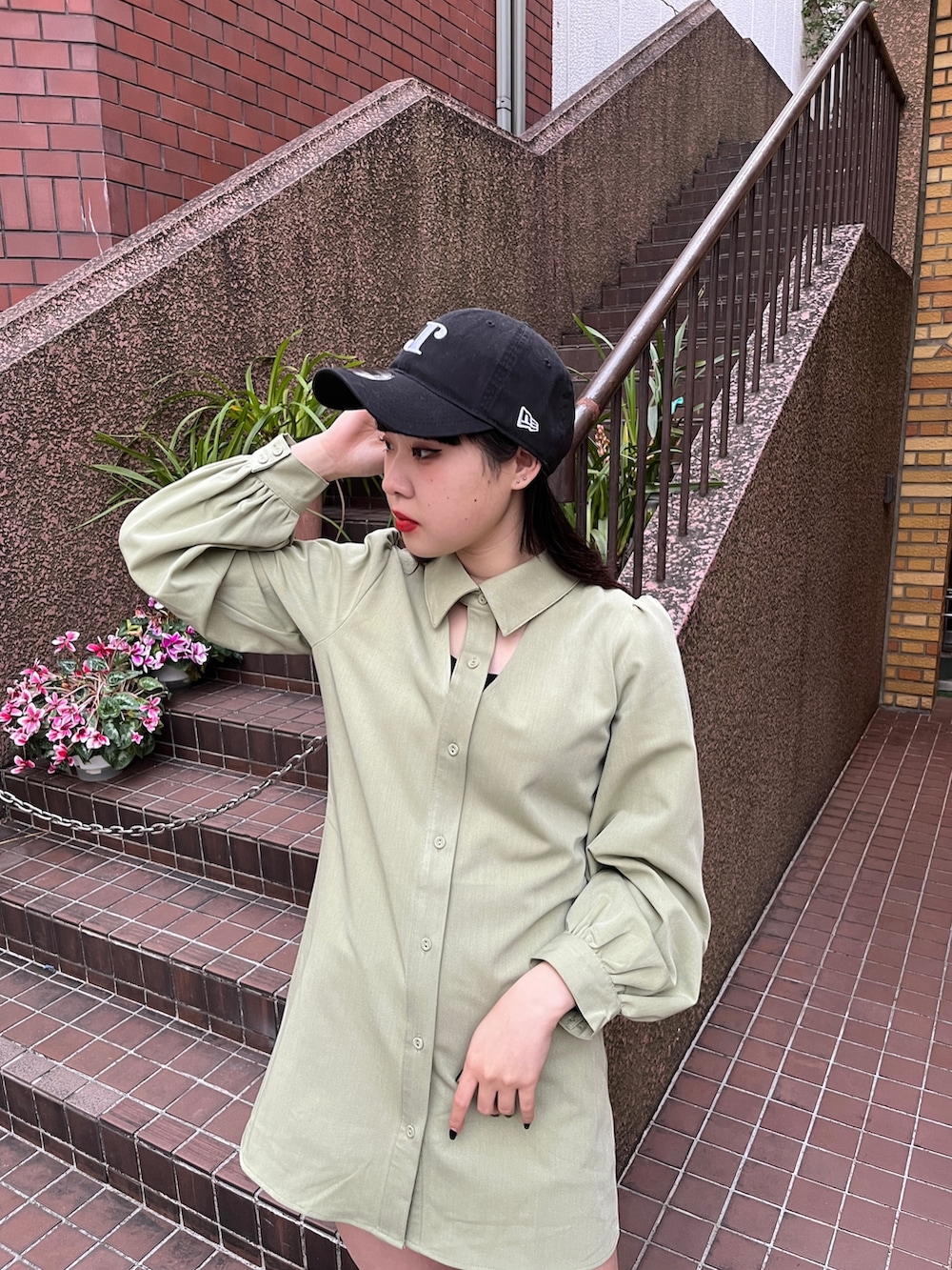 グリーン系のワンピース、ブラック系のブーツ、ブラック系のキャップを着用したレディースの冬コーディネートの5枚目の写真