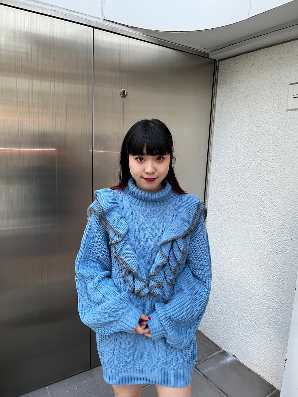 ブルー系のニット/セーター、ブラック系のブーツを着用したレディースの冬コーディネートの8枚目の写真