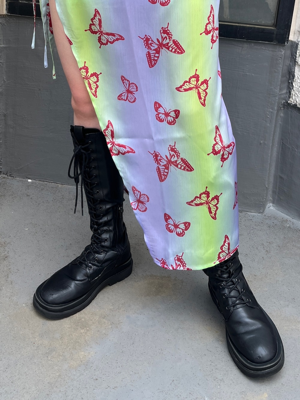 パープル系のワンピース、ブラック系のTシャツ/カットソー、ブラック系のブーツを着用したレディースの春コーディネートの8枚目の写真