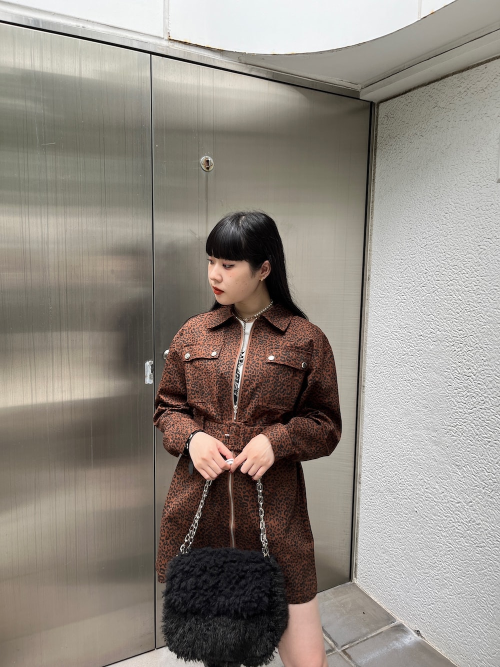 ブラック系のブーツ、ブラウン系のワンピース、ブラック系のハンドバッグを着用したレディースの夏コーディネートの5枚目の写真