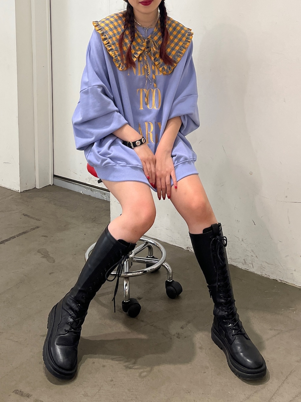 ブラック系のブーツ、パープル系のスウェット、ホワイト系のハンチング/ベレー帽を着用したレディースの秋コーディネートの2枚目の写真