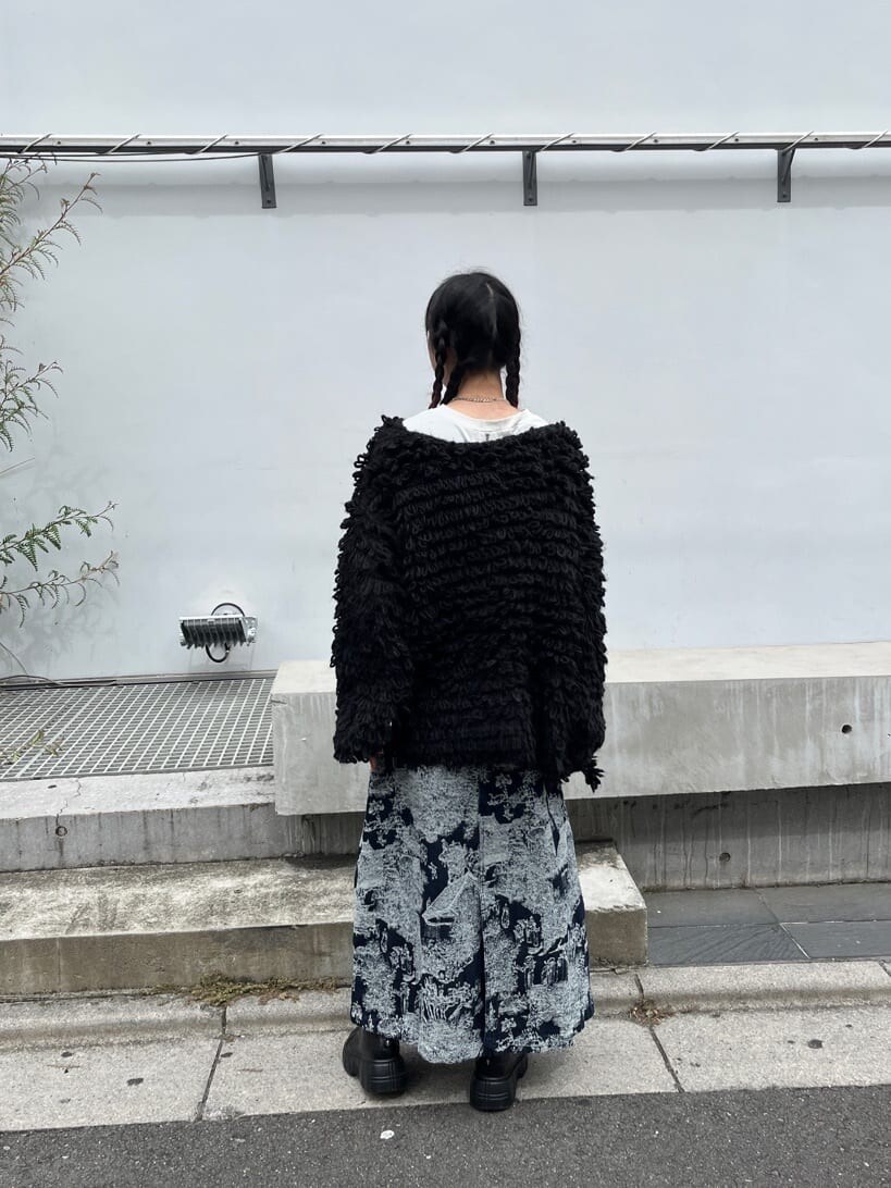 ブルー系のデニムスカート、ホワイト系のTシャツ/カットソー、ブラック系のカーディガン/ボレロを着用したレディースの秋コーディネートの3枚目の写真