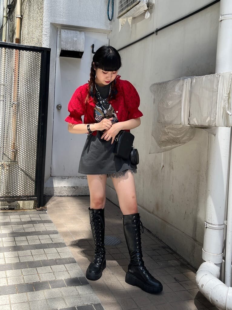 ブラック系のブーツ、ブラック系のデニムパンツ、レッド系のシャツ/ブラウスを着用したレディースの夏コーディネートの2枚目の写真