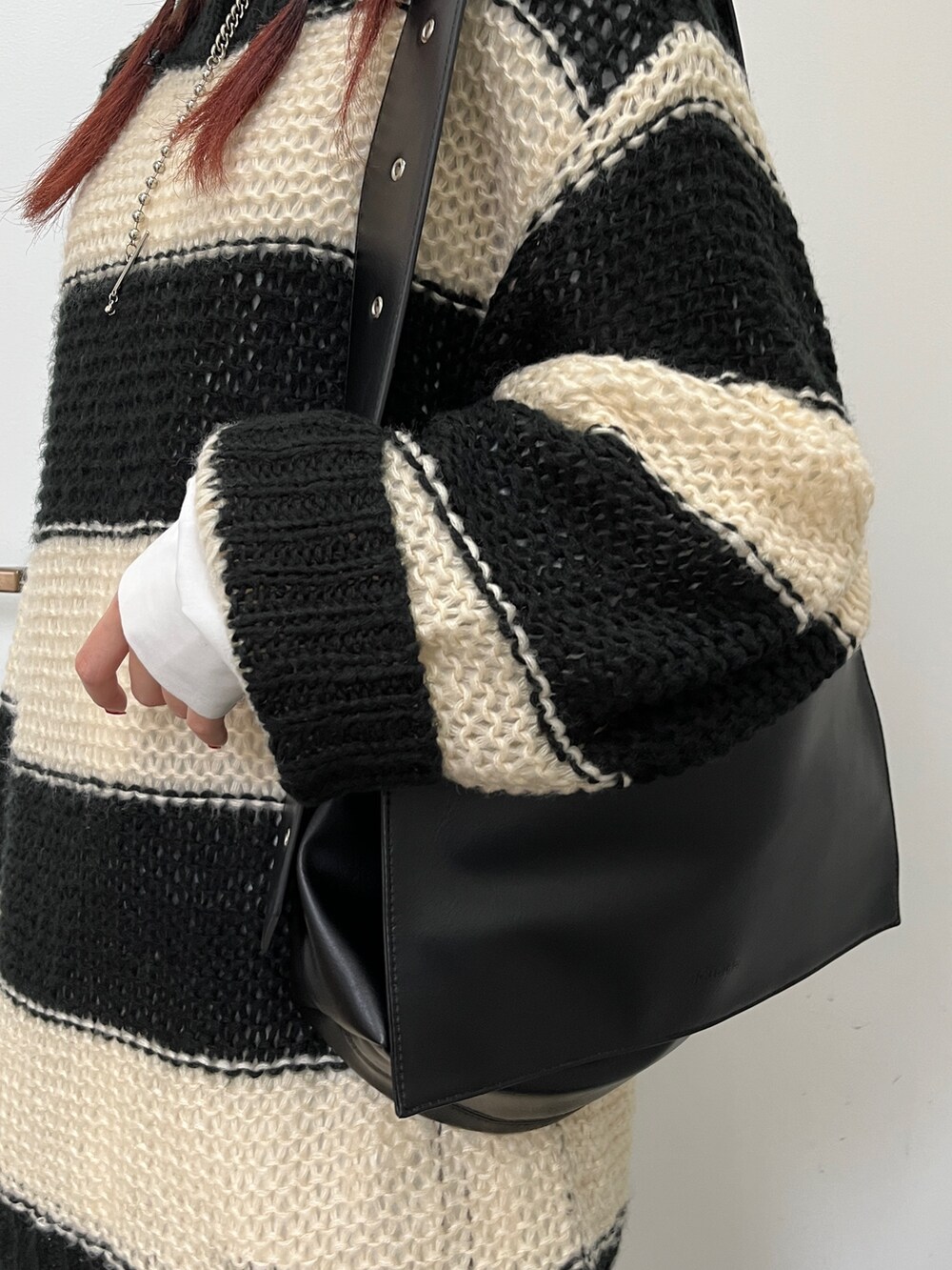 ホワイト系のシャツ/ブラウス、ブラック系のニット/セーター、ブラック系のハンチング/ベレー帽を着用したレディースの冬コーディネートの6枚目の写真