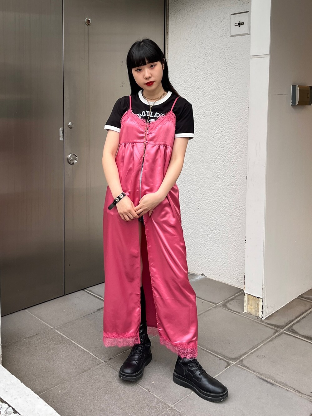 ピンク系のワンピース、ブラック系のブーツ、ブラック系のTシャツ/カットソーを着用したレディースの冬コーディネートの2枚目の写真