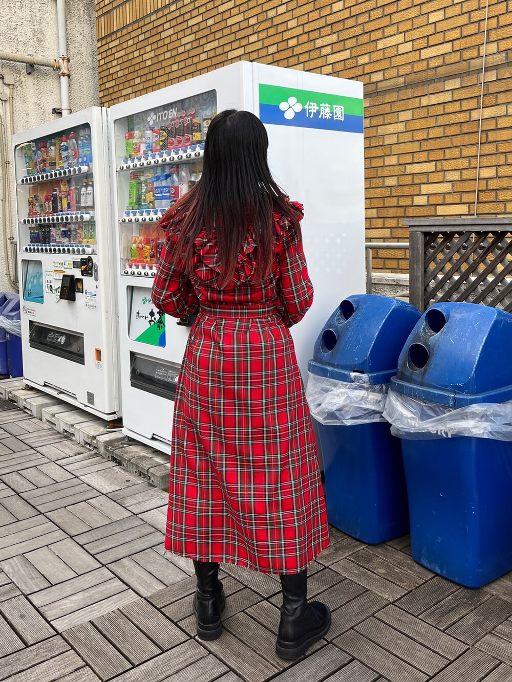 レッド系のワンピース、ブラック系のブーツを着用したレディースの冬コーディネートの3枚目の写真