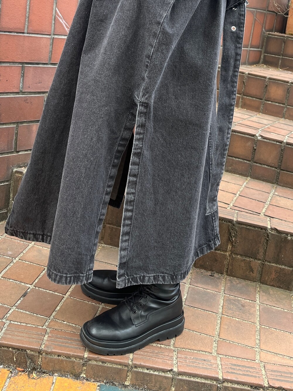 ブラック系のトレンチコート、ブラウン系のその他パンツ、ホワイト系のTシャツ/カットソーを着用したレディースの冬コーディネートの7枚目の写真