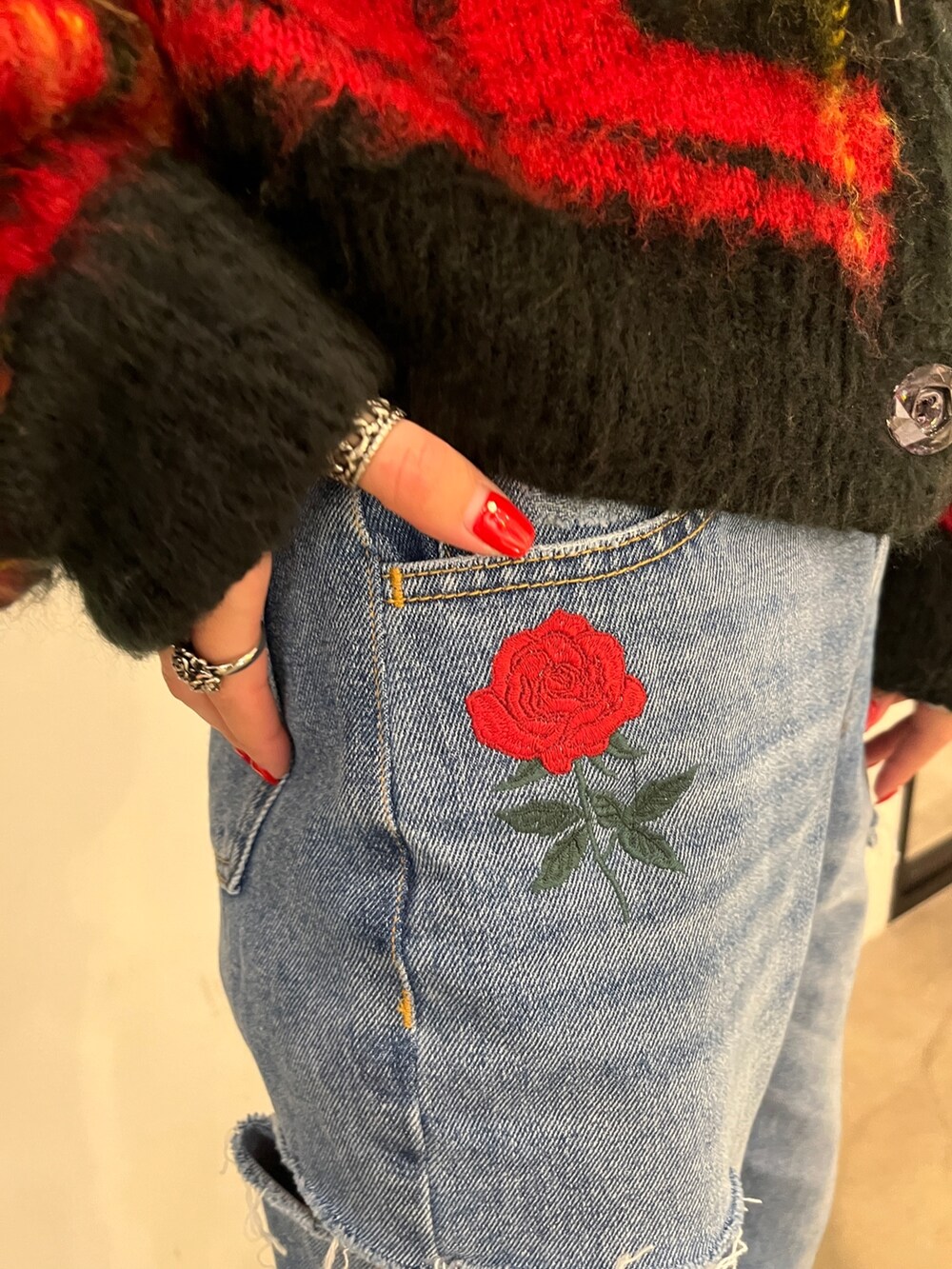 ブラック系のその他シューズ、レッド系のカーディガン/ボレロ、ブルー系のデニムパンツを着用したレディースの秋コーディネートの6枚目の写真