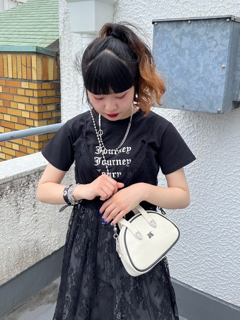 ブラック系のワンピース、ブラック系のデニムパンツ、ホワイト系のボストンバッグを着用したレディースの夏コーディネートの4枚目の写真