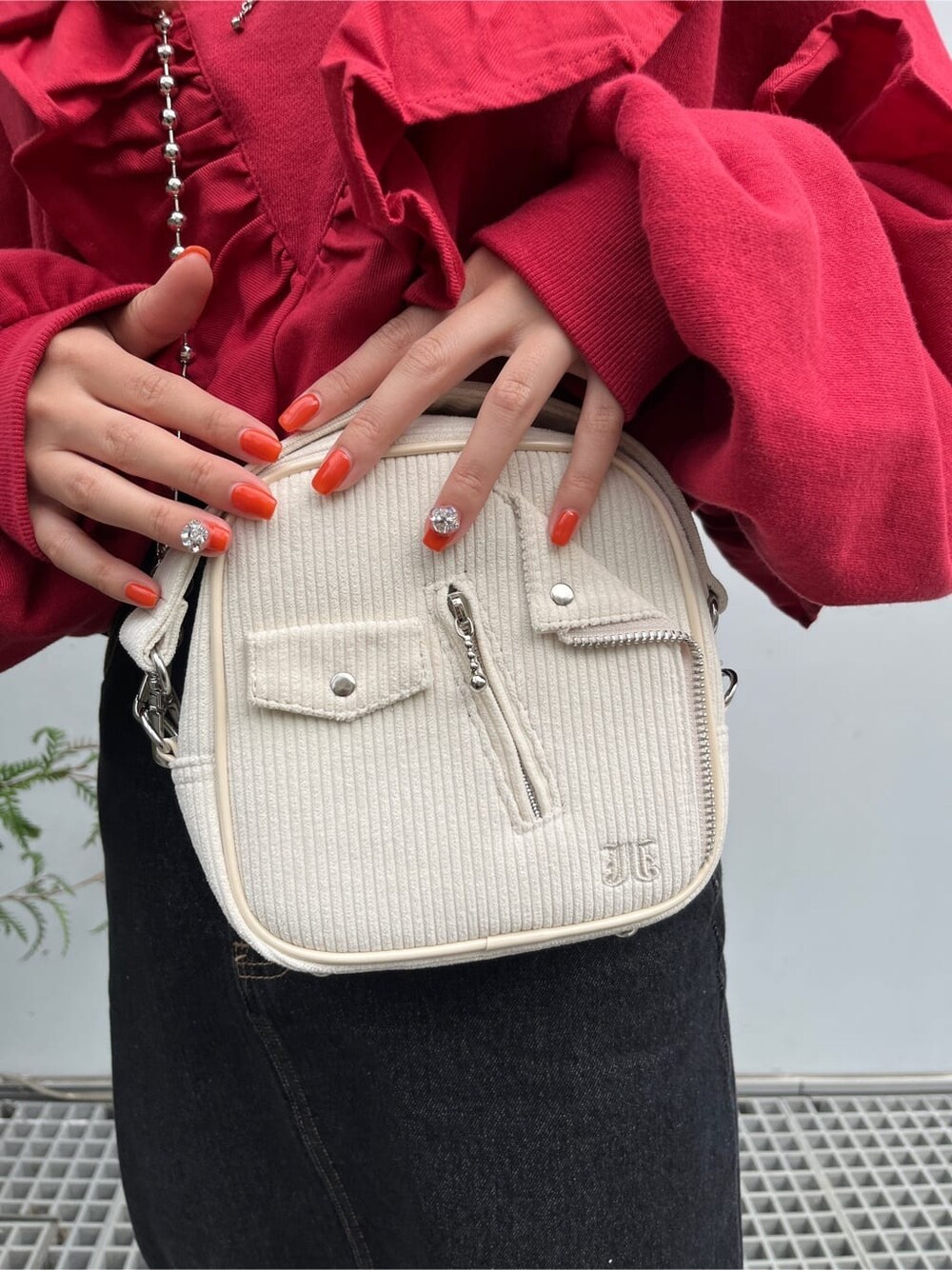 ホワイト系のハンドバッグ、ブラック系のデニムスカート、レッド系のTシャツ/カットソーを着用したレディースの秋コーディネートの6枚目の写真