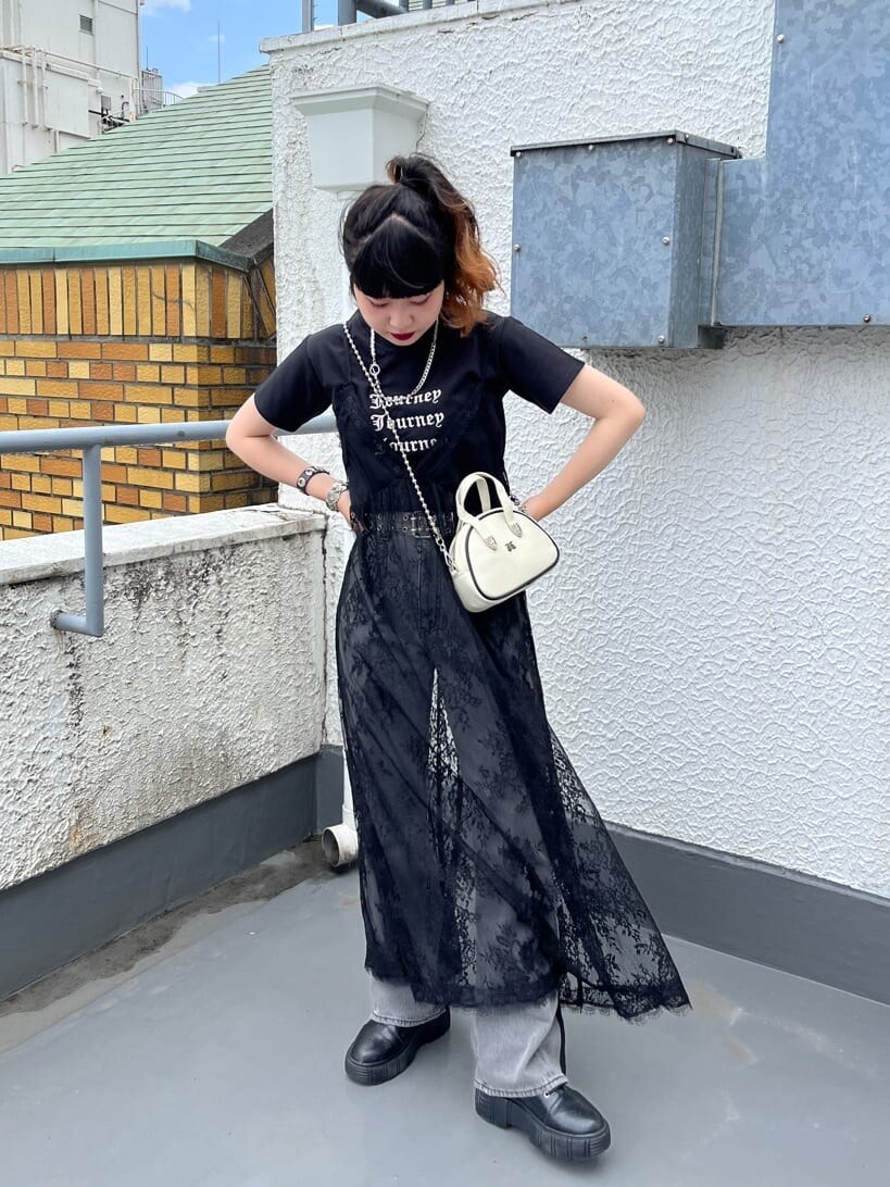 ブラック系のワンピース、ブラック系のデニムパンツ、ホワイト系のボストンバッグを着用したレディースの夏コーディネートの2枚目の写真