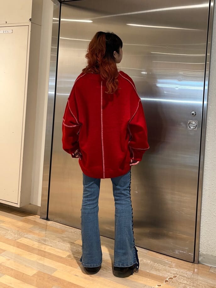 レッド系のニット/セーター、ホワイト系のTシャツ/カットソーを着用したレディースの冬コーディネートの3枚目の写真