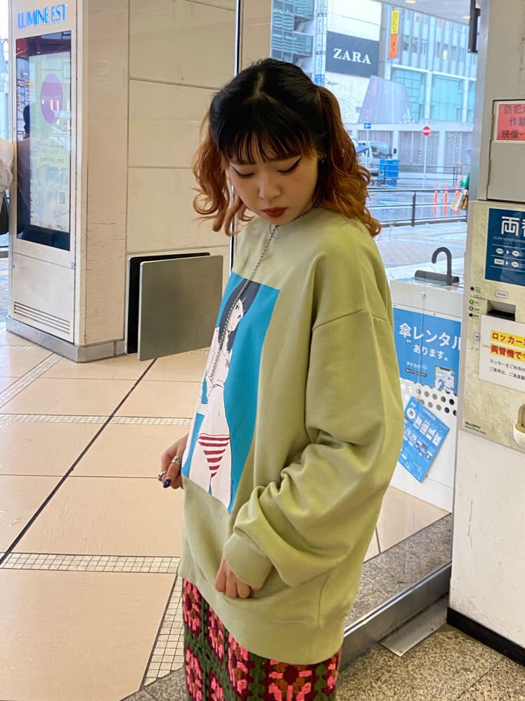 グリーン系のスカート、グリーン系のスウェットを着用したレディースの秋コーディネートの3枚目の写真