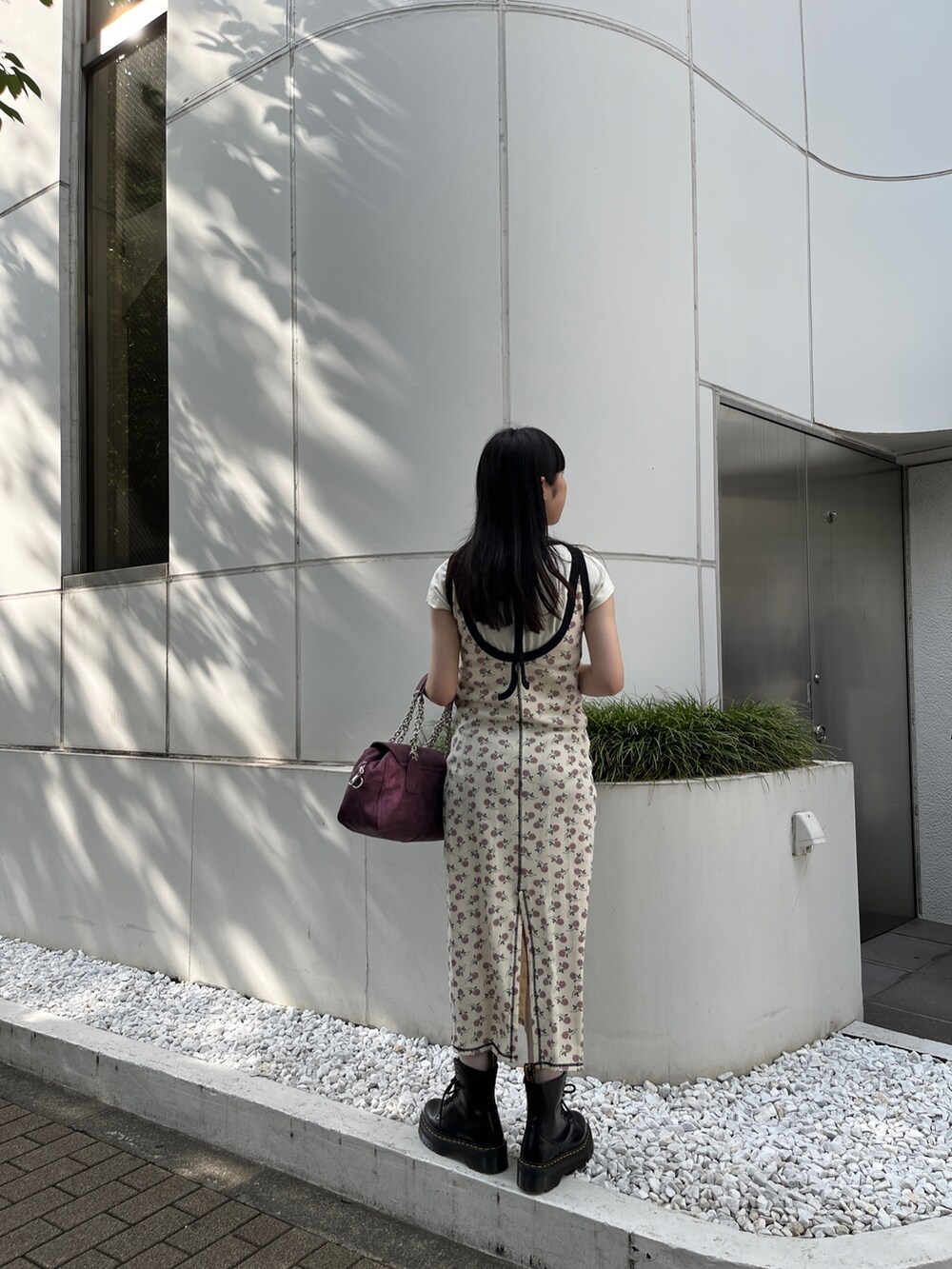 ホワイト系のワンピース、ブラック系のハンドバッグ、ホワイト系のタンクトップを着用したレディースの夏コーディネートの2枚目の写真