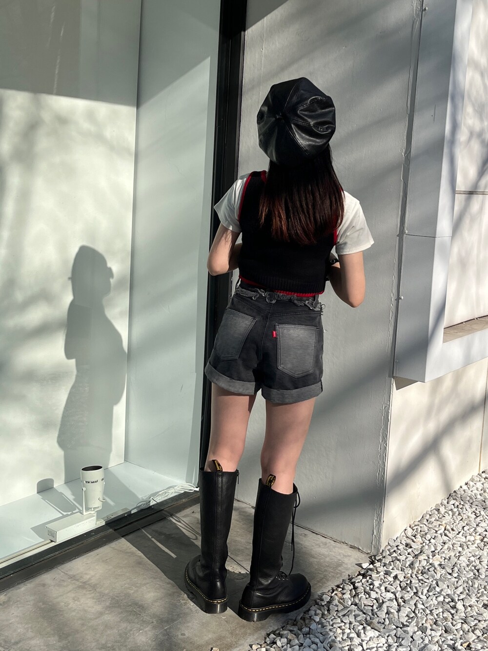 ブラック系のタンクトップ、ブルー系のデニムパンツ、ブラック系のハンチング/ベレー帽を着用したレディースの冬コーディネートの3枚目の写真