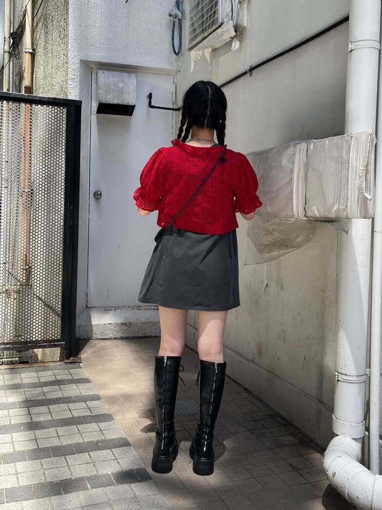 ブラック系のブーツ、ブラック系のデニムパンツ、レッド系のシャツ/ブラウスを着用したレディースの夏コーディネートの3枚目の写真