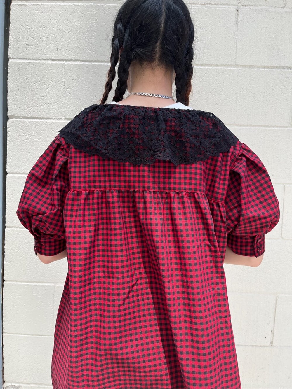 レッド系のシャツ/ブラウス、ブラック系のデニムパンツ、ブラック系のブーツを着用したレディースの夏コーディネートの5枚目の写真