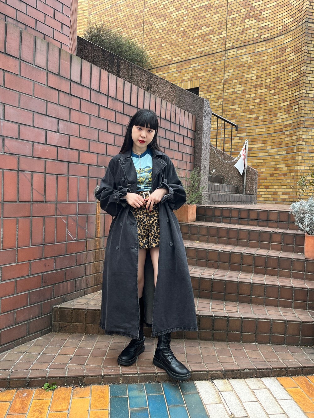 ブラック系のトレンチコート、ブラウン系のその他パンツ、ホワイト系のTシャツ/カットソーを着用したレディースの冬コーディネートの2枚目の写真