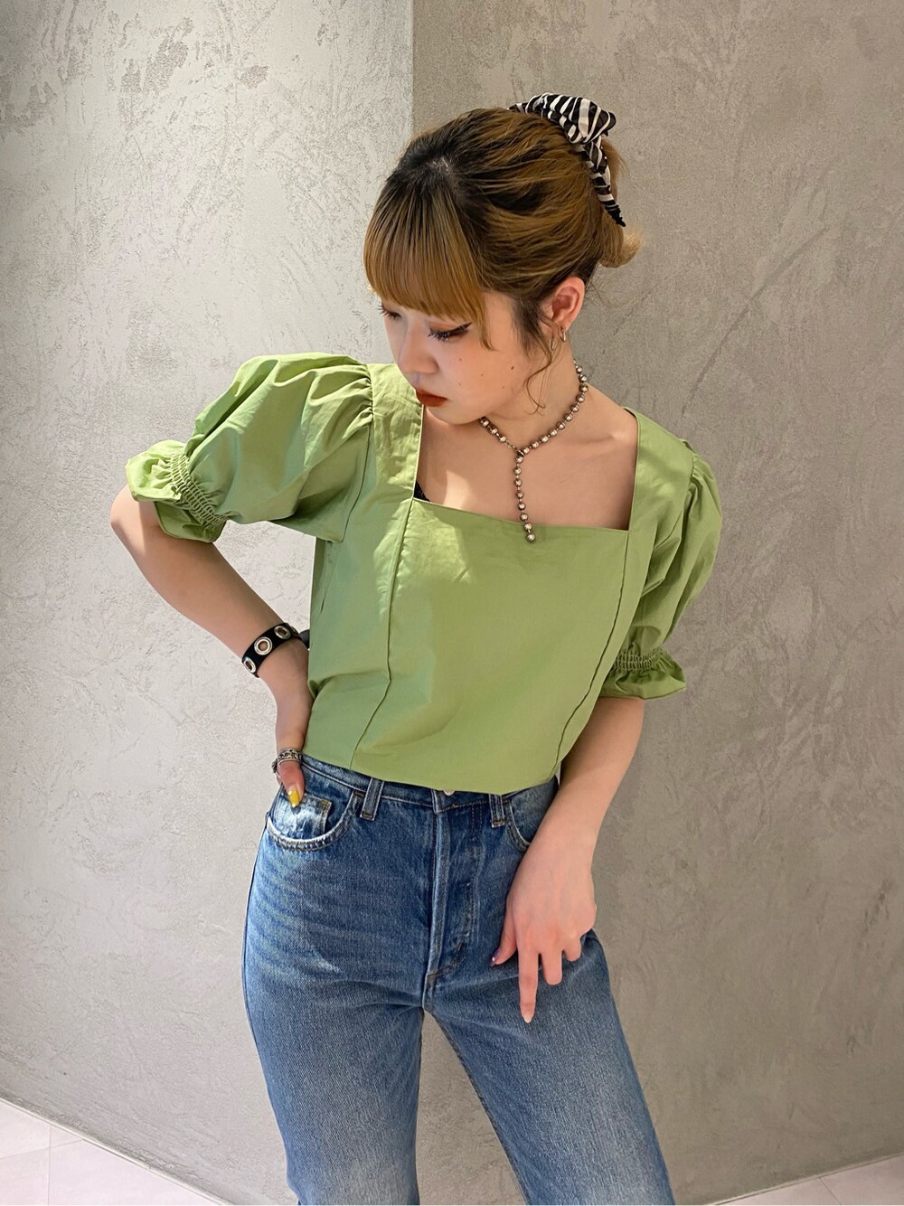 グリーン系のシャツ/ブラウス、ブルー系のデニムパンツを着用したレディースの春コーディネートの3枚目の写真