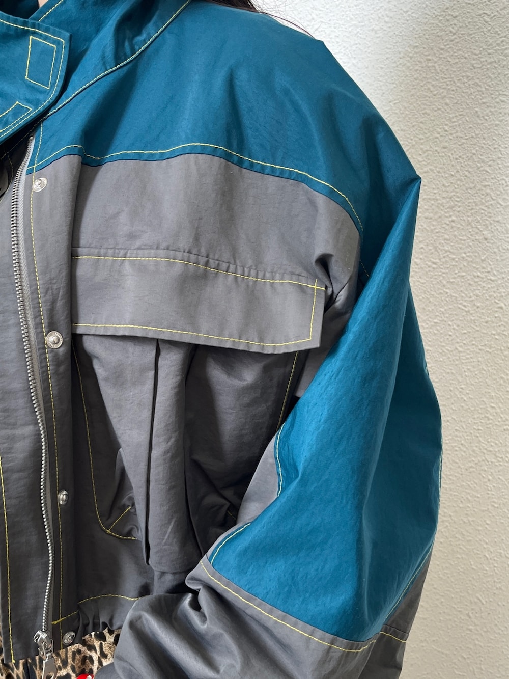 グリーン系のブルゾン、ブラウン系のその他パンツ、ホワイト系のタンクトップを着用したレディースの秋コーディネートの7枚目の写真