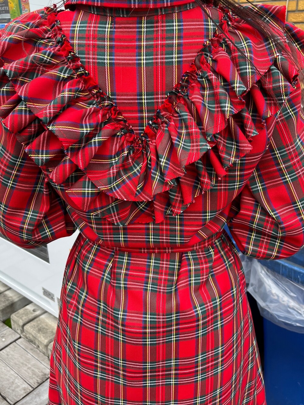 レッド系のワンピース、ブラック系のブーツを着用したレディースの冬コーディネートの7枚目の写真