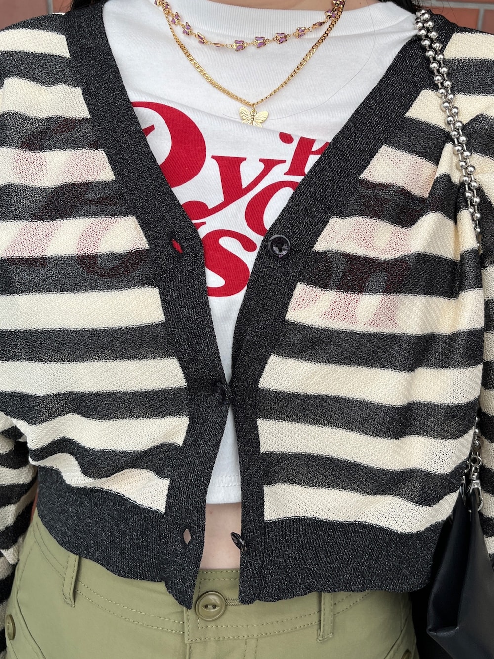 グリーン系のスカート、ブラック系のカーディガン/ボレロ、ホワイト系のTシャツ/カットソーを着用したレディースの夏コーディネートの7枚目の写真