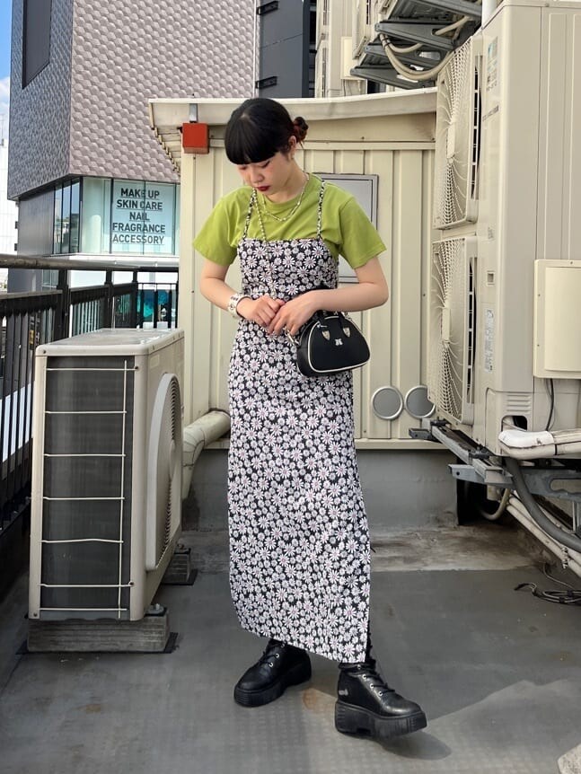 ブラック系のブーツ、グリーン系のTシャツ/カットソー、ブラック系のワンピースを着用したレディースの夏コーディネートの2枚目の写真