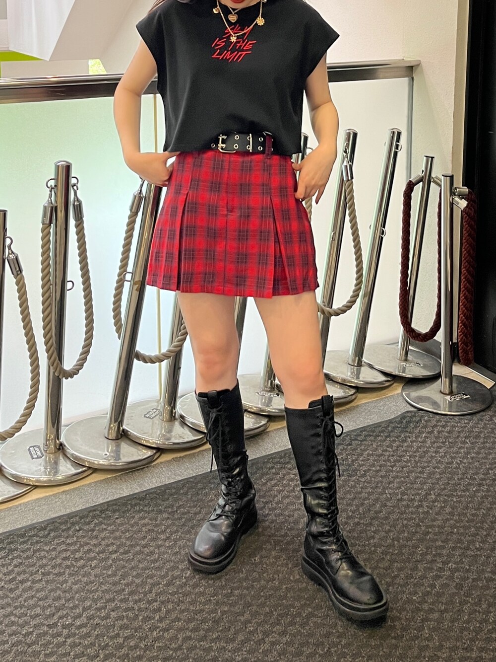 ブラック系のタンクトップ、レッド系のその他パンツ、ブラック系のブーツを着用したレディースの夏コーディネートの2枚目の写真