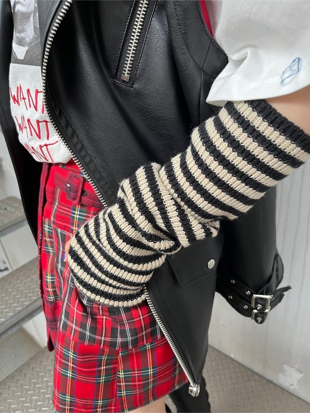 ブラック系のライダースジャケット、レッド系のその他パンツ、ホワイト系のTシャツ/カットソーを着用したレディースの夏コーディネートの8枚目の写真